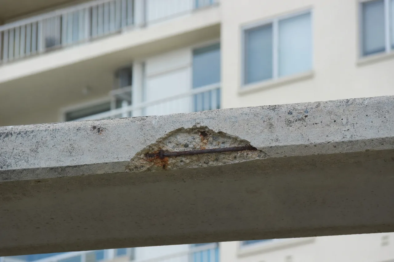 A balcony slab edge with a small patch of broken concrete and rust — concrete cancer repair, Sunshine Coast. Illustrative example.